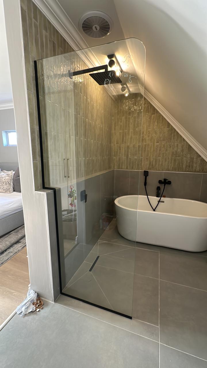 Attic bathroom renovation — walk-in glass shower, freestanding bath and green zellige tiling