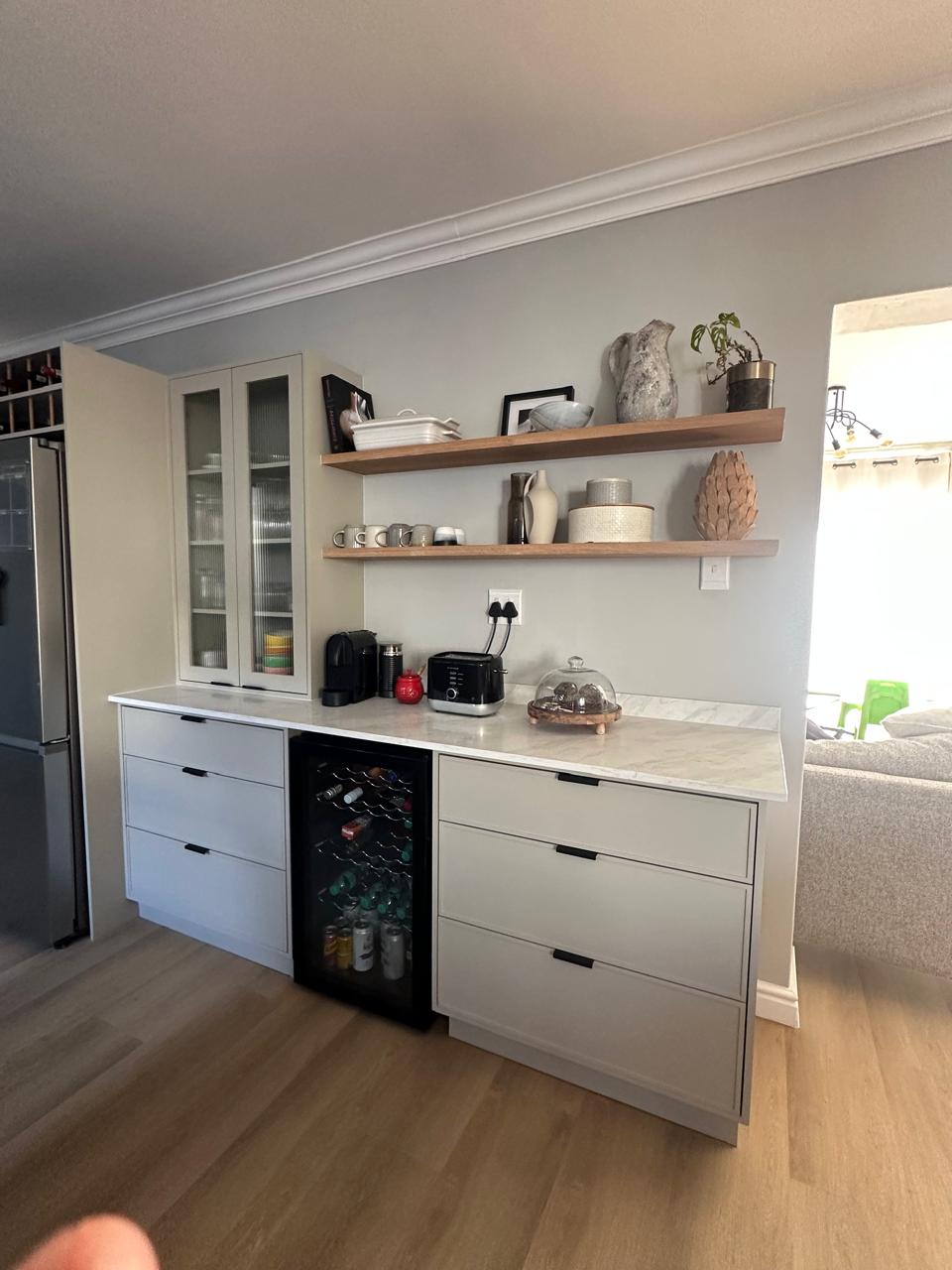 Built-in pantry and beverage cabinet with marble worktop, wine fridge and timber shelves