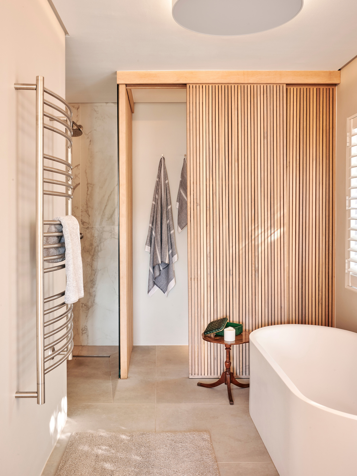 Studio Collective interior — bathroom with timber slat screen and freestanding bath