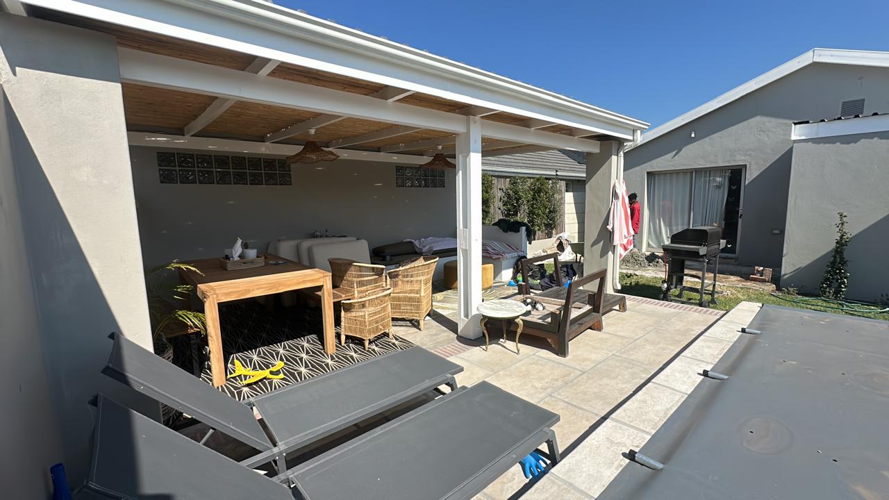 Covered outdoor patio with timber ceiling, tiled entertainment area and pool deck