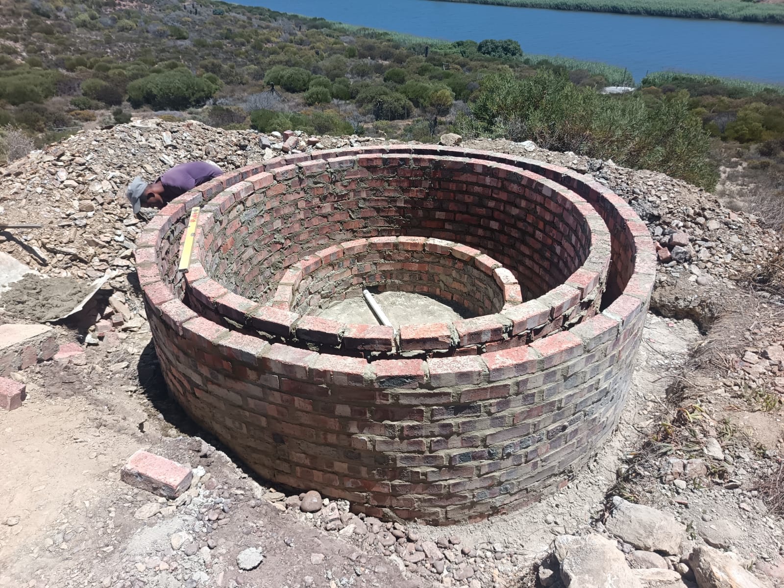 Hand-built circular brick reservoir overlooking the lagoon