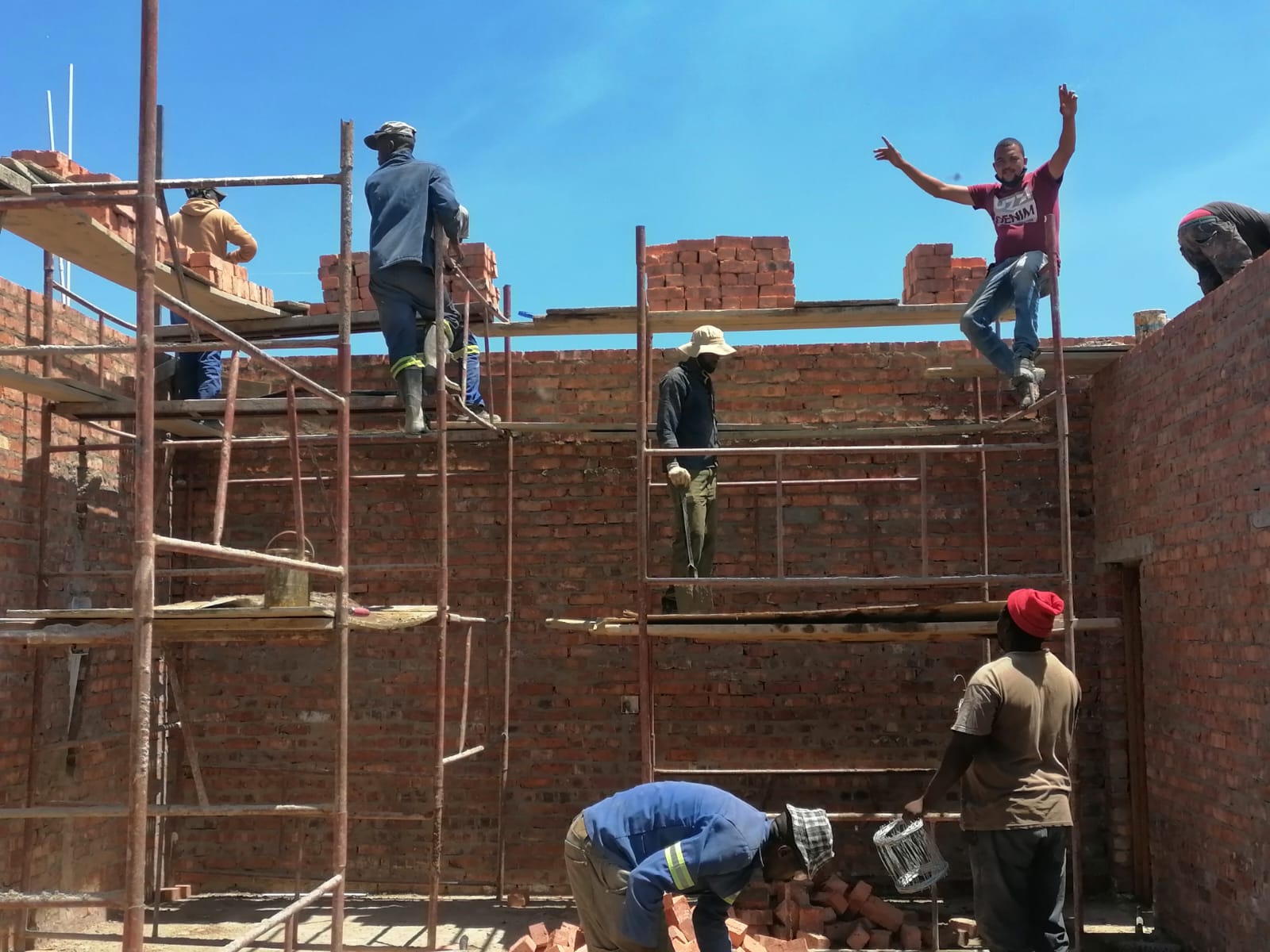 Tiger bricklaying crew on scaffolding raising facebrick walls