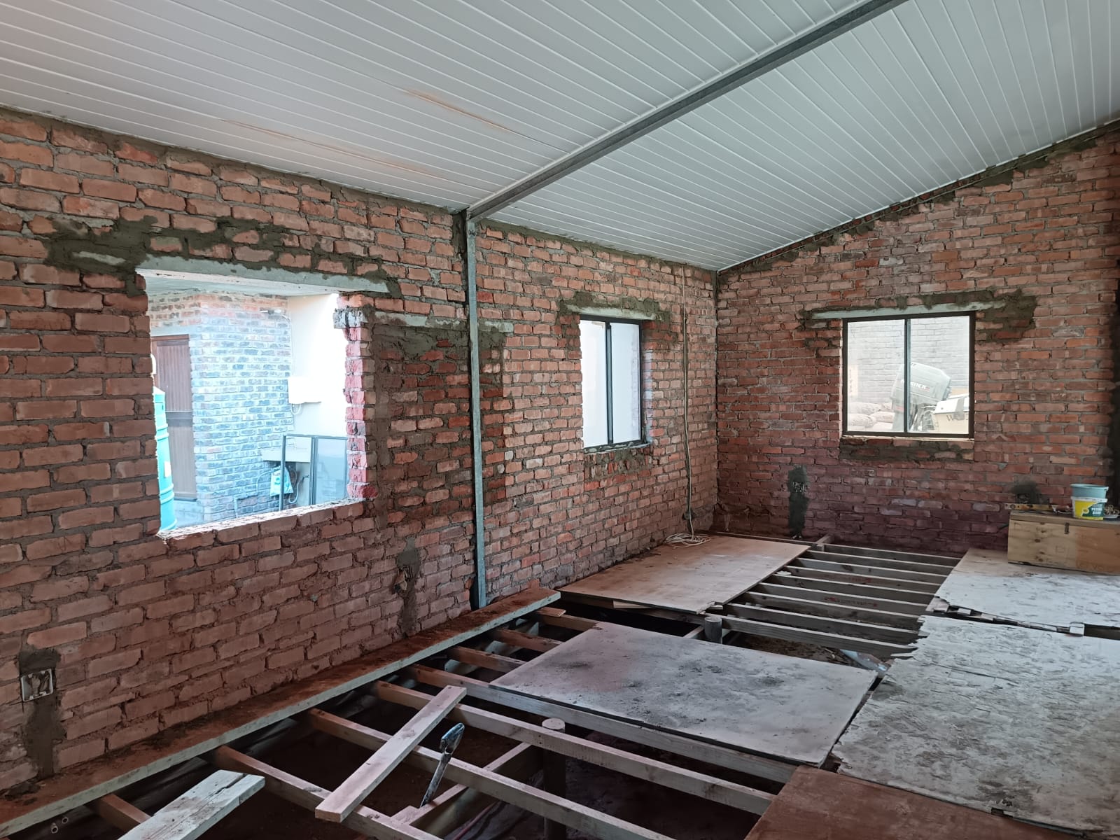 Interior renovation — exposed brick walls, new lintels and timber sub-floor